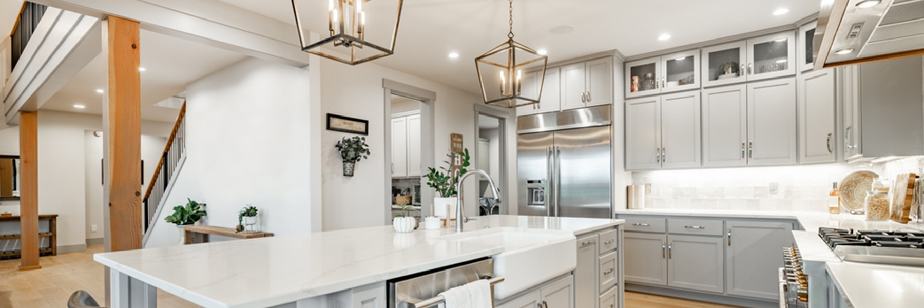 Modern kitchen with professional electrical installation featuring recessed lighting pendant lights over island white cabinets stainless steel appliances and under cabinet lighting residential electrical services