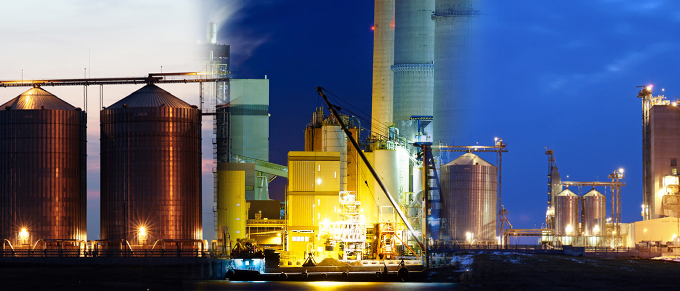 Industrial agricultural processing facility at night with illuminated grain silos and conveyor systems commercial generator services for agricultural operations