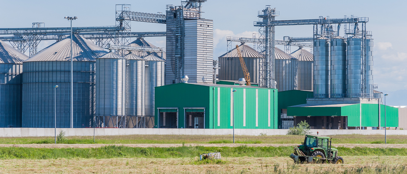 Agricultural grain elevator facility with green industrial buildings and silos in rural setting professional electrical installation services for agricultural operations