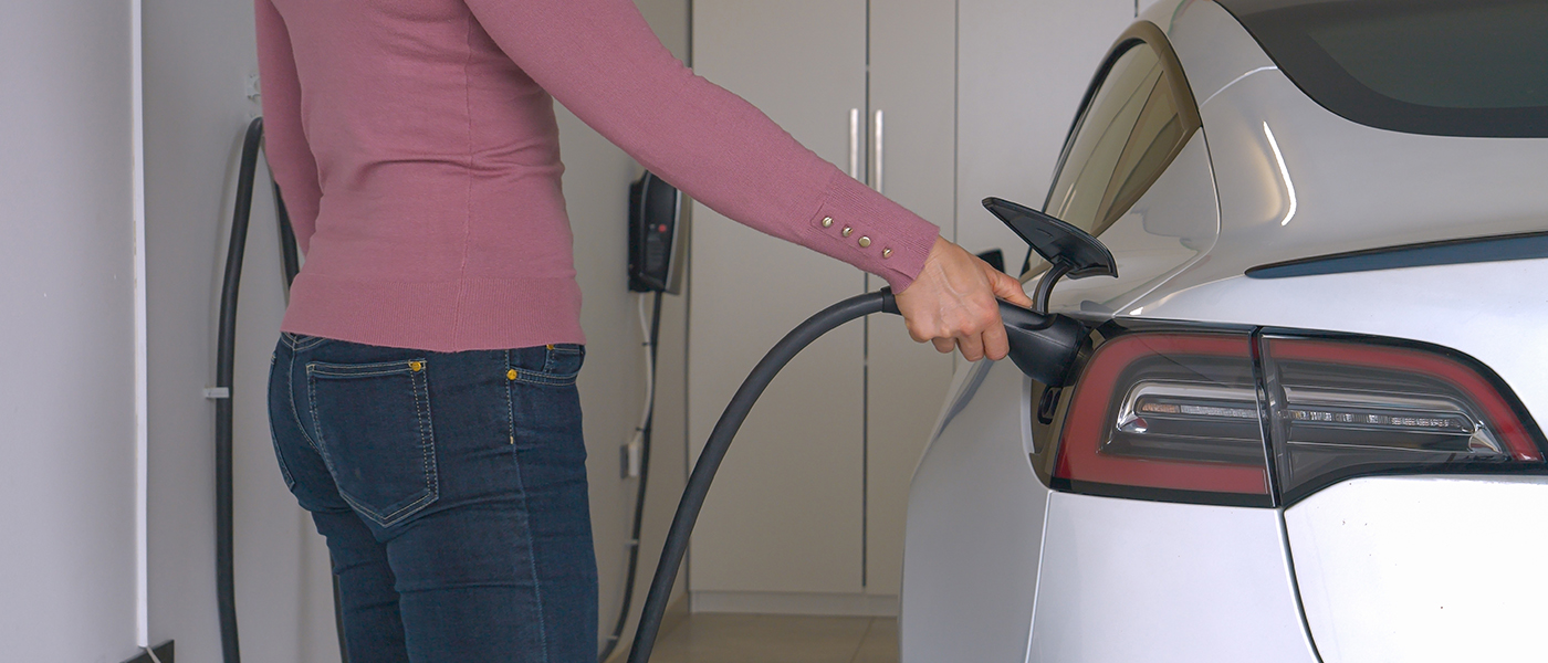 Electric vehicle charging at commercial garage installation with professional charging station equipment for business use