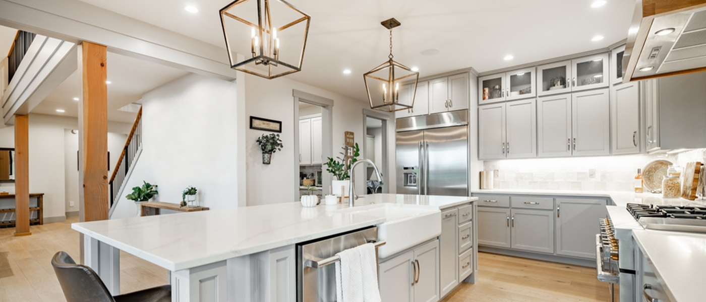Modern kitchen with professional electrical installation featuring recessed lighting pendant lights over island white cabinets stainless steel appliances and under cabinet lighting residential electrical services