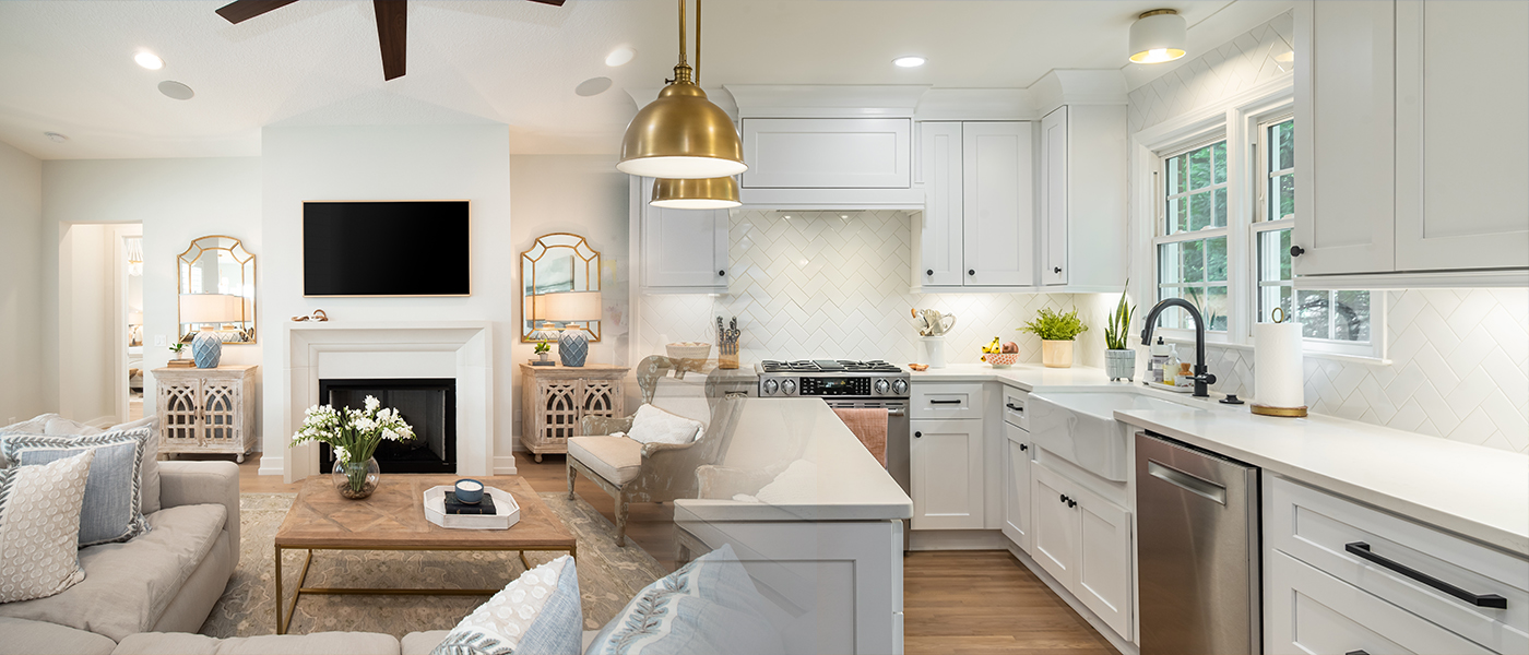 Modern white kitchen and living room with professional LED recessed lighting installation and brass pendant lights residential electrical services