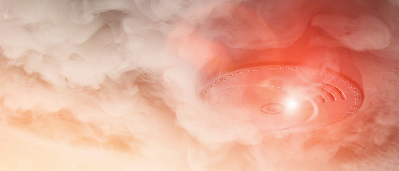 Residential smoke alarm activated amid smoke, reliable fire alarm installation and home safety systems