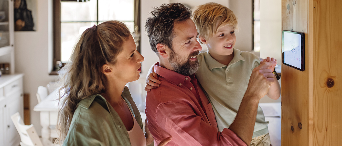 Family interacting with a smart home control panel, adjusting home automation settings together in a bright living space